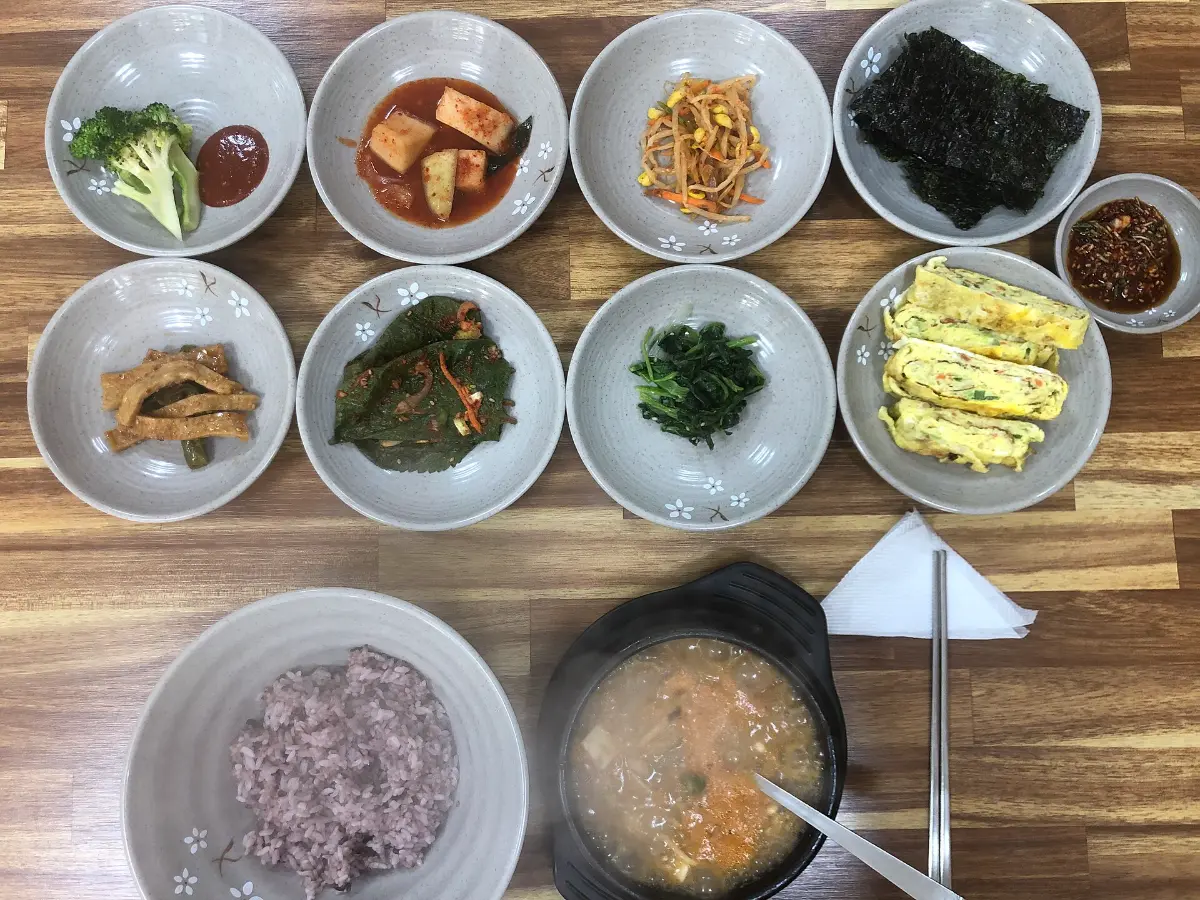 나무 상 위에 반찬 여덟 가지와 잡곡밥, 국이 놓인 아침상